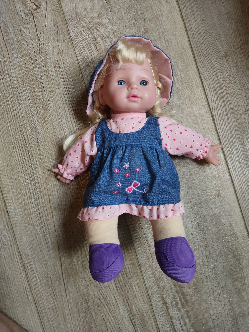 Blonde Baby Doll in Pink Outfit with Denim Pinafore and Purple Shoes